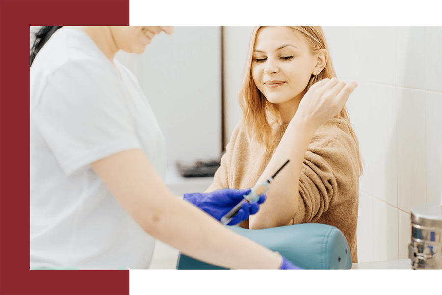 Female phlebotomist preparing equipment before taking a blood sample.