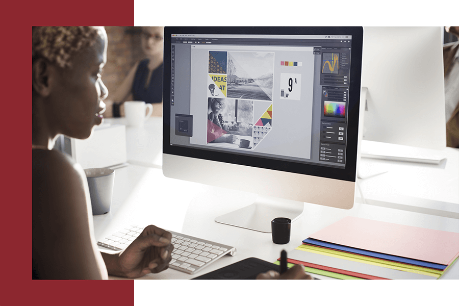 Woman focused on her computer screen, creating a design with a look of concentration.