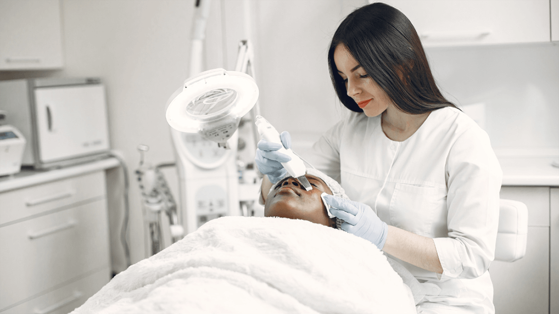 An esthetician providing a relaxing skincare treatment, showcasing career flexibility and fulfillment.